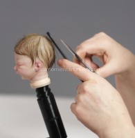 Nikki Holland rooting hair into reborn doll Photo